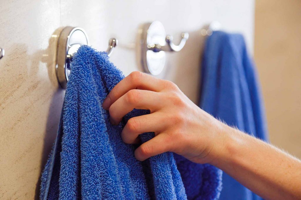 A woman grabbing a towel after using an infrared sauna