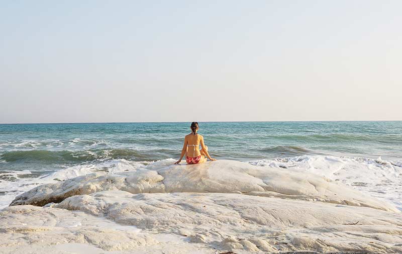 A woman on the beach, benefiting from natural halotherapy